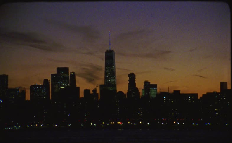 An abstract, blurry view of the New York City skyline at dusk slowly comes into focus in this vintage-style shot