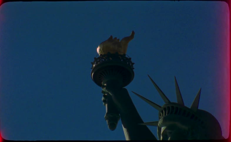 A 16mm clip pans up the Statue of Liberty, ending with a dramatic film burn effect against a clear blue sky
