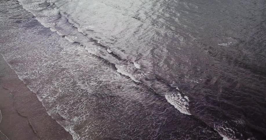 The waves slowly hit the reflective sand