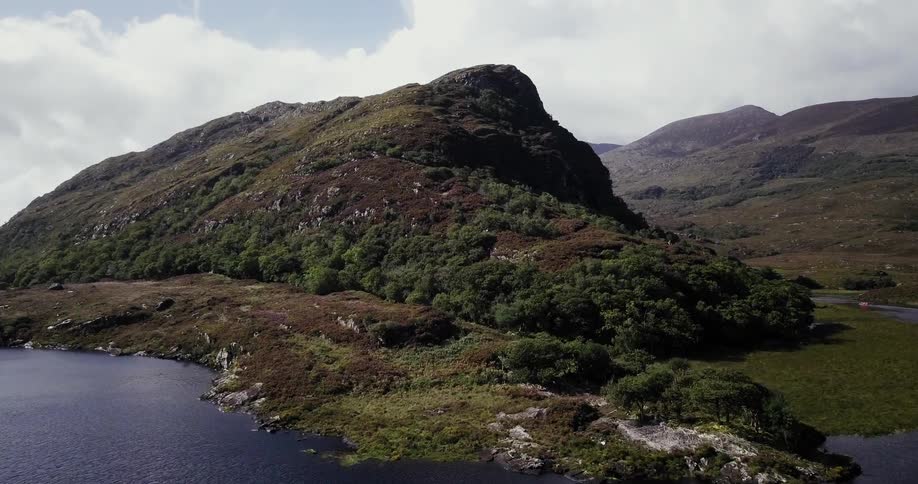 A lake leads to a small green mountain