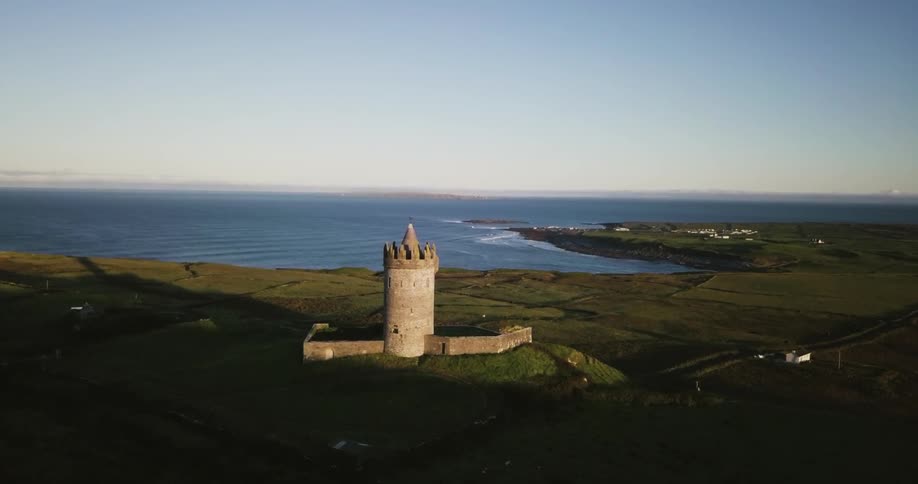A stone tower on a grassy hill