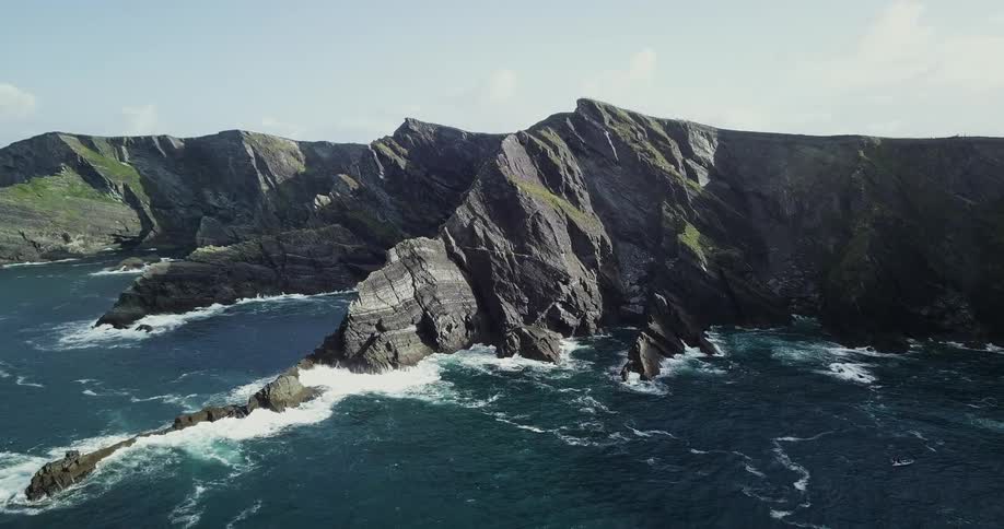 The waves crash against the mountains ahead