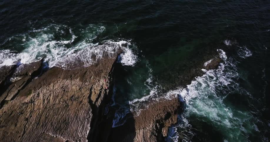 Ocean waves splash up against the rocks