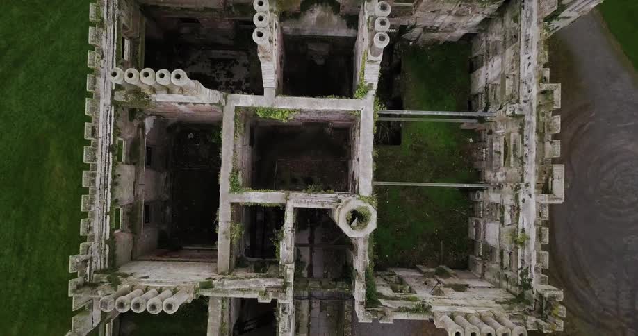 Moss and overgrowth cover an abandoned building with no roof