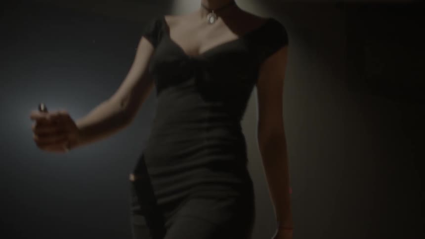 A woman wearing a black dress is dancing on stage