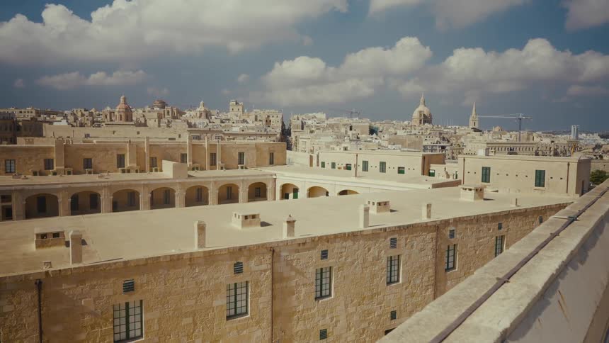 A scenic view of the rooftops and skyline of Valletta, Malta, under a partly cloudy sky