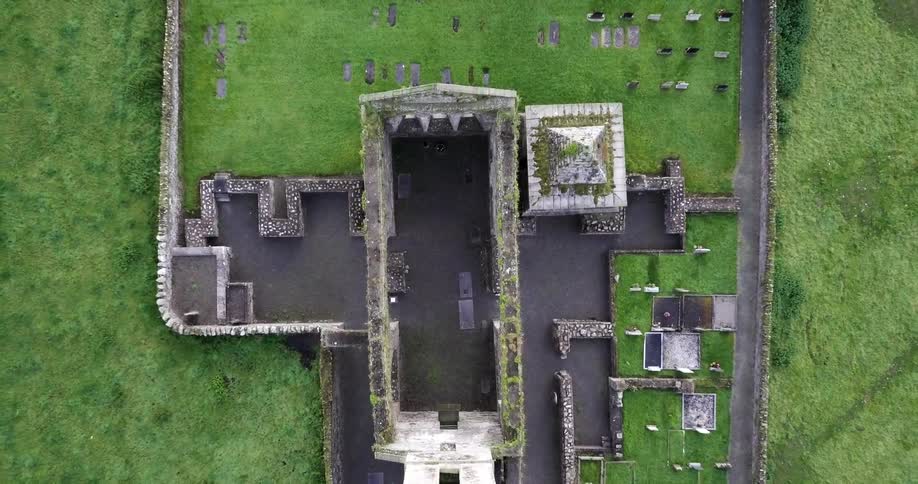 An abandoned building with no roof is covered with moss