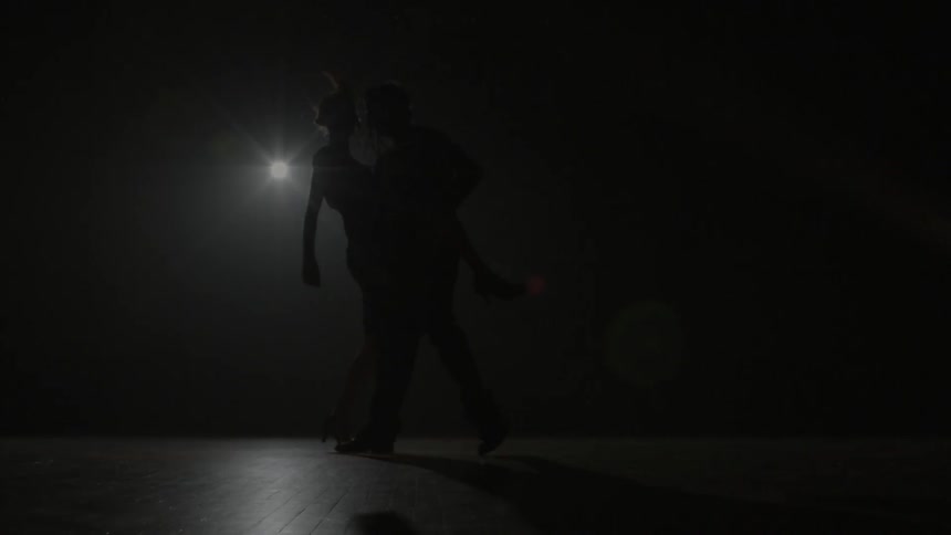 A man and woman dance in an empty room