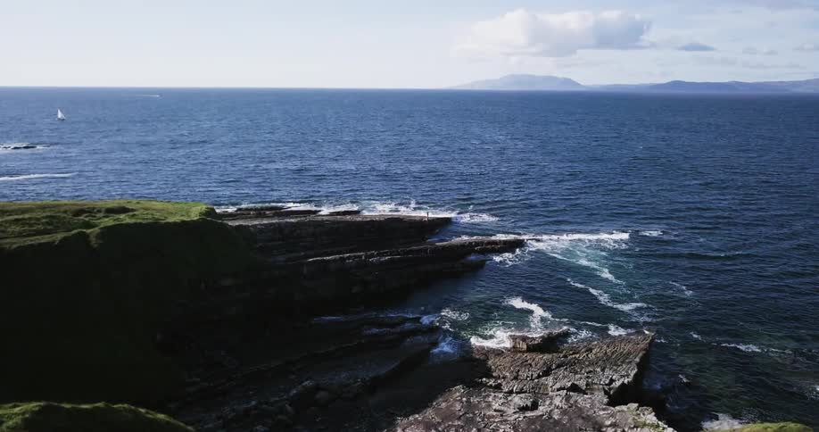 Water crashes onto a large stretch of rock
