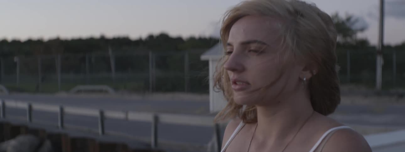 A woman is standing next to something and staring off in the distance