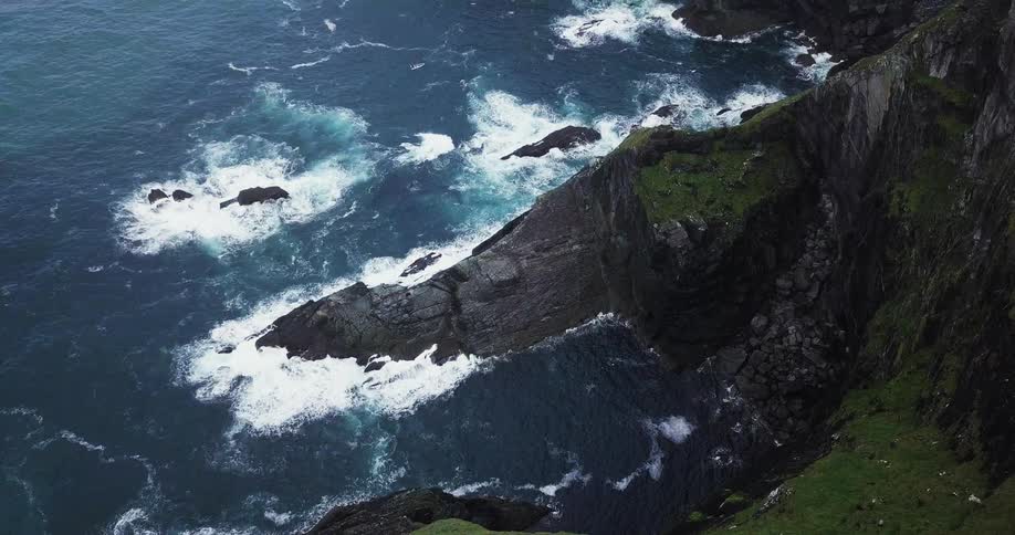 Ocean waves crash into a rocky cliff