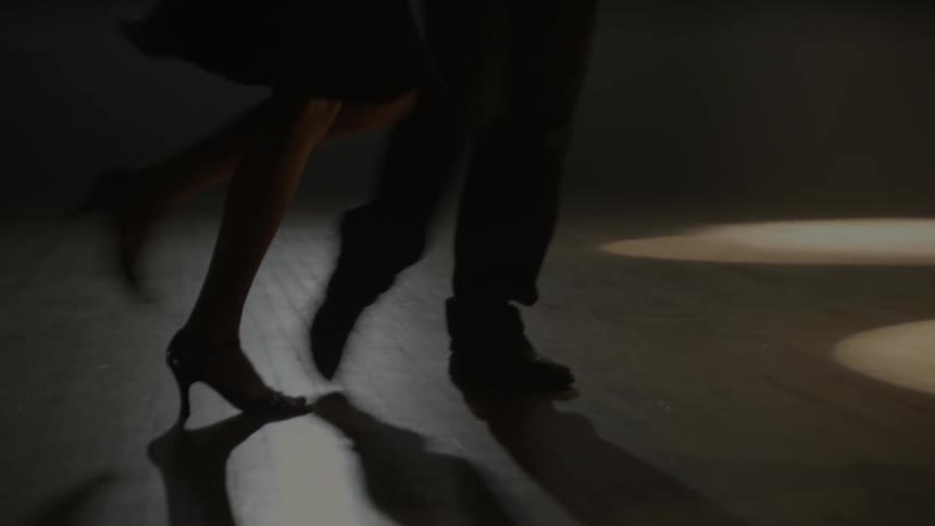 A man and woman dance on a wood floor