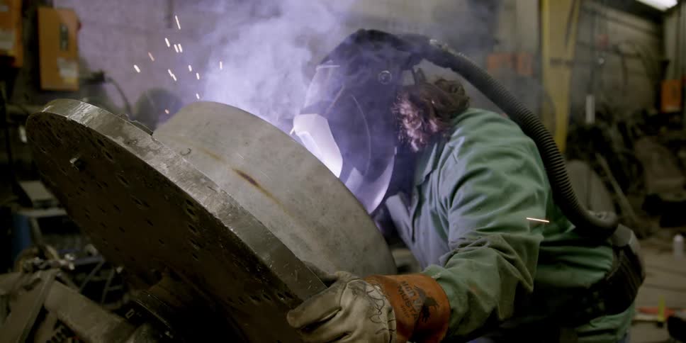 A person has a welding mask on as they work