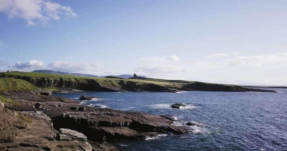 Ocean water flowing up onto rocky beaches on sunny day