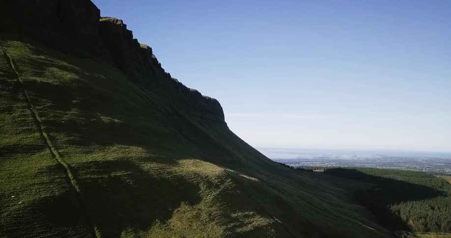 The large mountain is giving off a huge shadow on one side