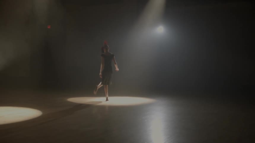 A woman with a mask twirls around on the dance floor