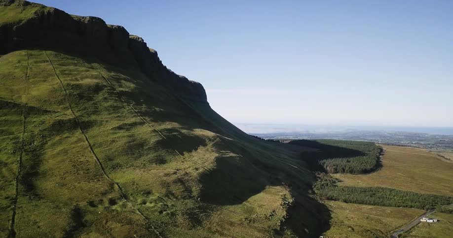 The tall mountain is covered with green