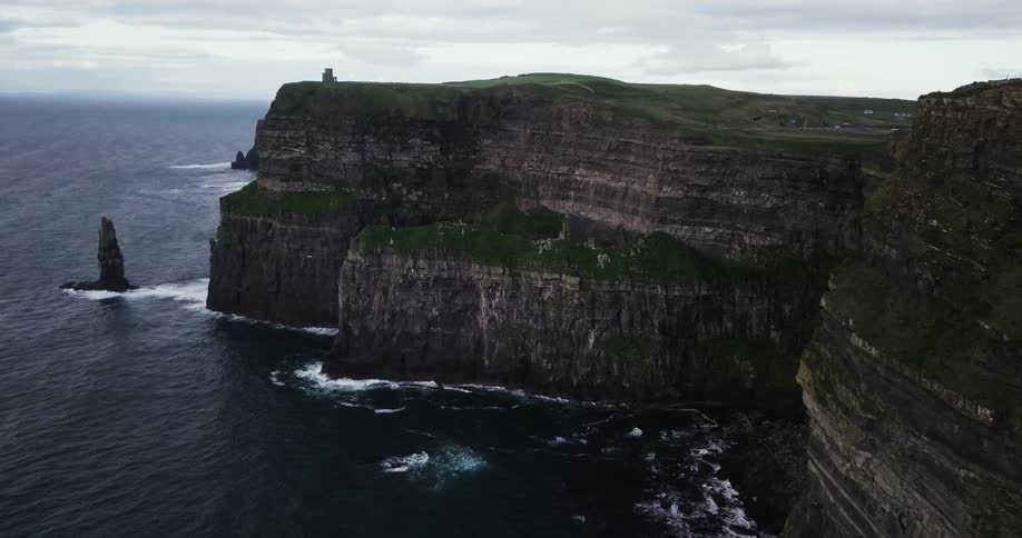 Ocean water crashes at the base of a seaside cliff