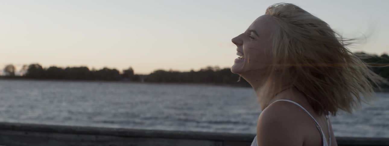 A woman laughs while the wind blows through her hair