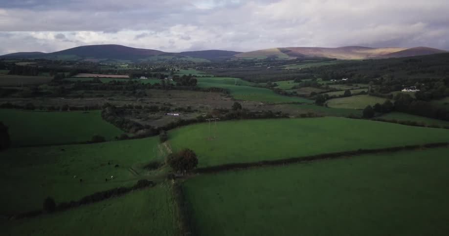 The pastures below are green and full of hills