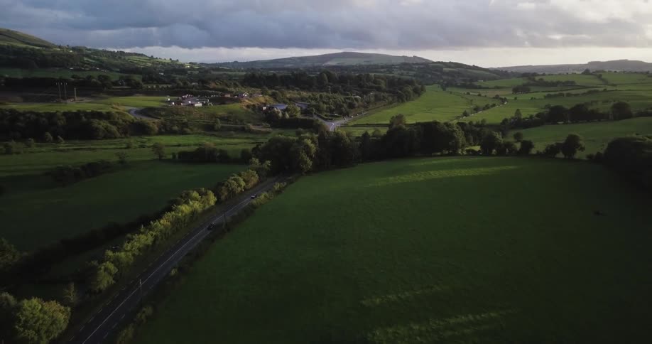 A road runs through the green pastures below