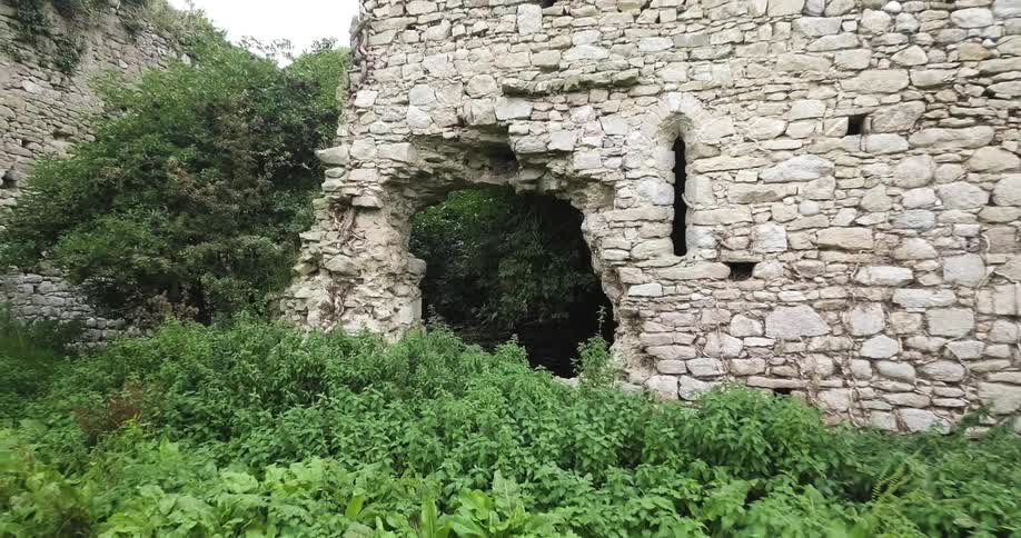 Ruins of abandoned stone building on cloudy day