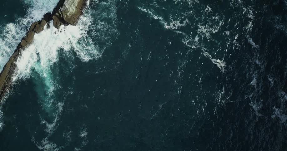 Heavy waves crash against rocks in the water