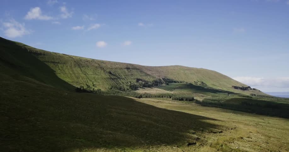The hillsides are lined, and covered with green on a sunny day