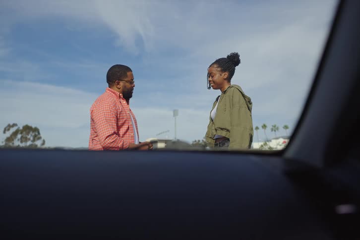 A loving father hands over the car keys to his excited daughter, who gives him a kiss before they get in the car