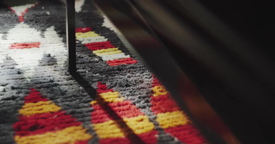A prism light leak effect distorts the view of a colorful, patterned rug in a moody interior shot