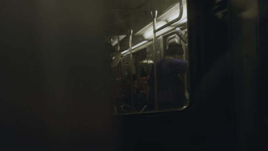 People sand and sit in a moving train