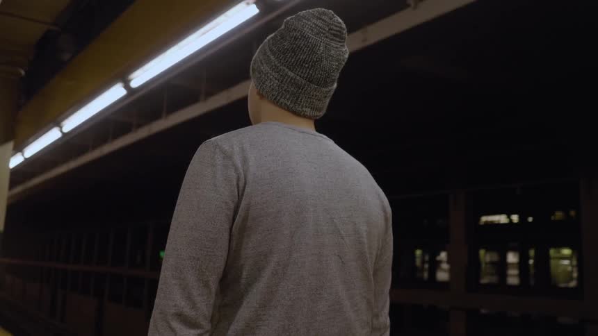 A man is waiting for a train at a station