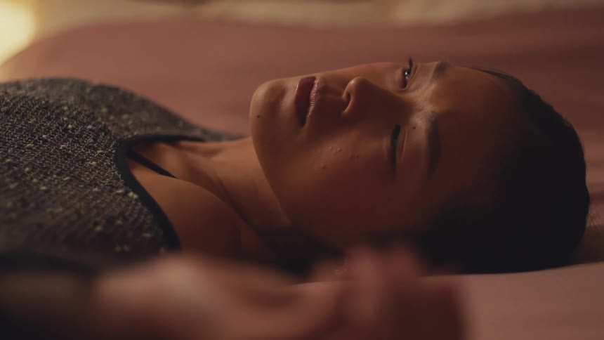 A woman peacefully wakes up from her sleep and slowly sits up in her warm, cozy bed