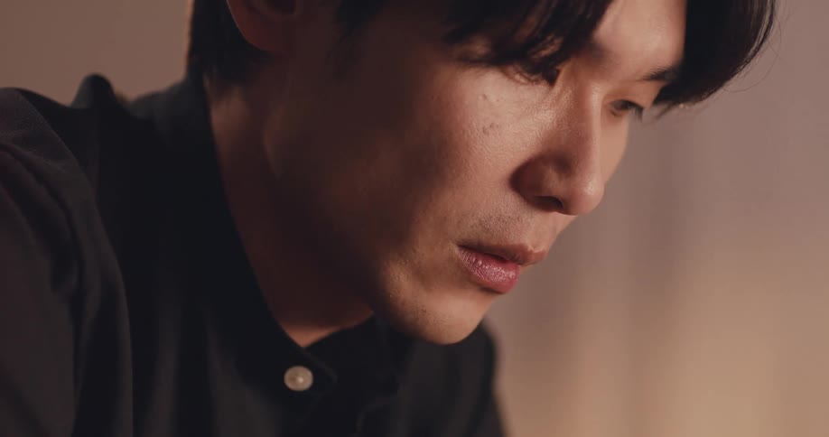 Close up of a sad Asian man talking on a mobile phone