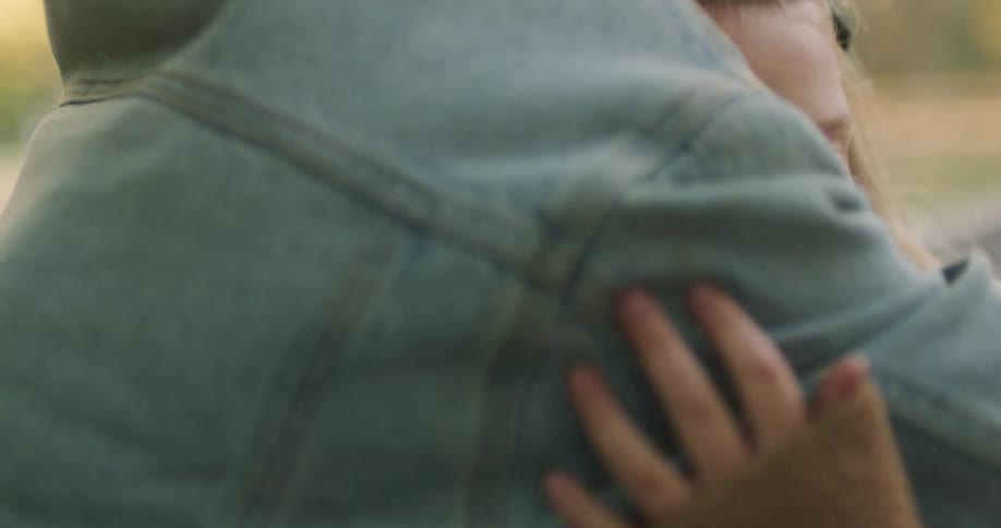 An empathetic child comforts a sad little girl with a reassuring hug while sitting together outside