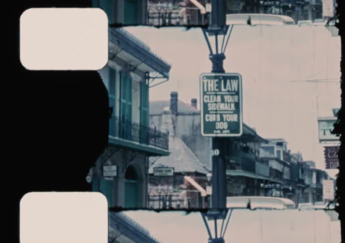 Vintage home movie footage captures a street scene and the entrance to Jackson Square in the French Quarter of New Orleans, Louisiana