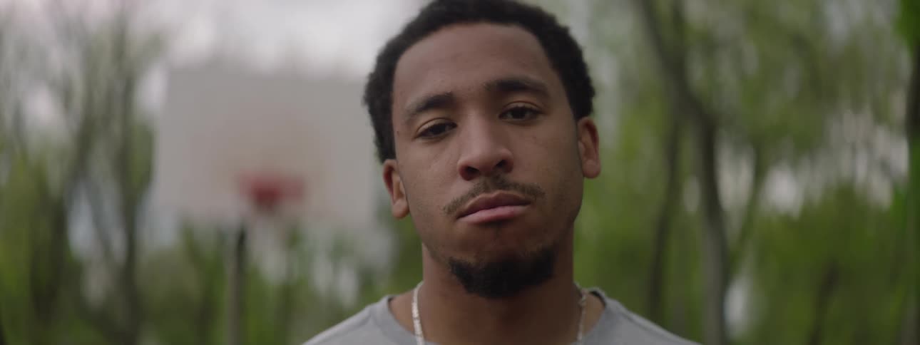 Slow motion close up of a thoughtful young African American man looking into the camera on a basketball court