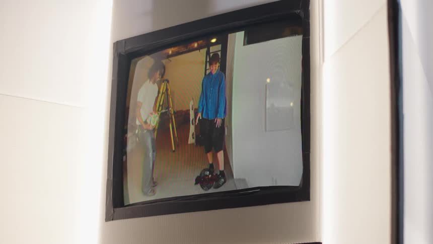 A retro CRT television displays an old home video of two young men juggling a soccer ball in a garage