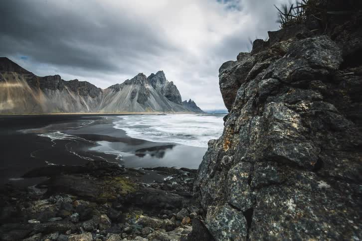 A cinematic timelapse reveals the dramatic Vestrahorn mountain range and black sand beach under a stormy sky