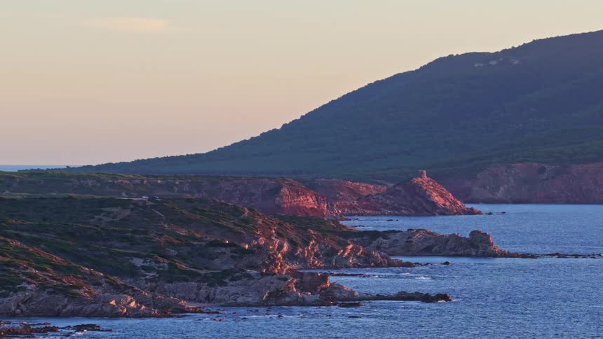 A beautiful coastal landscape in Sardinia, Italy, with a historic tower on the cliffs during golden hour