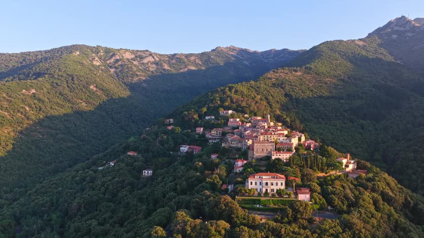 Aerial view of a picturesque historic village nestled in the mountains at sunrise