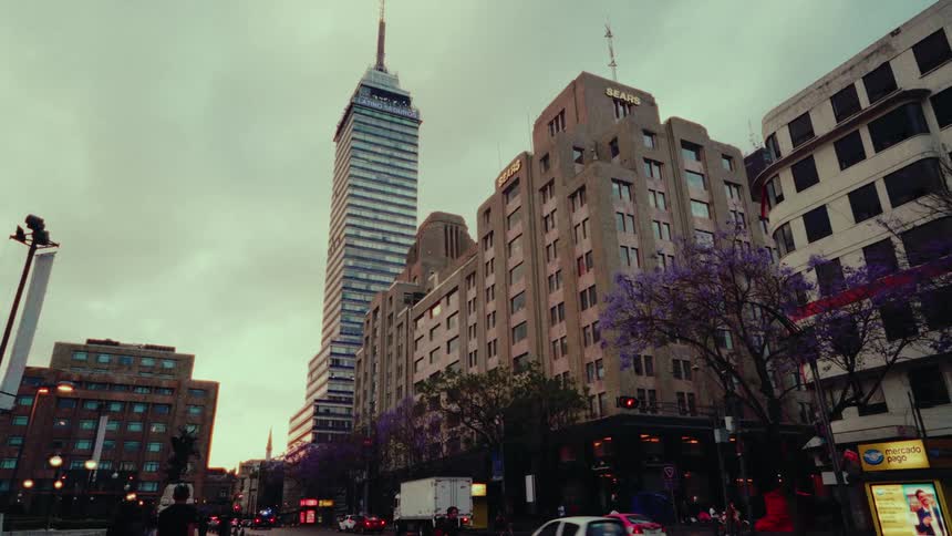 Evening falls on a classic Mexico City street with the famous Torre Latinoamericana against a cloudy sky