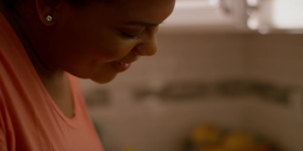 A woman is working in a kitchen smiling