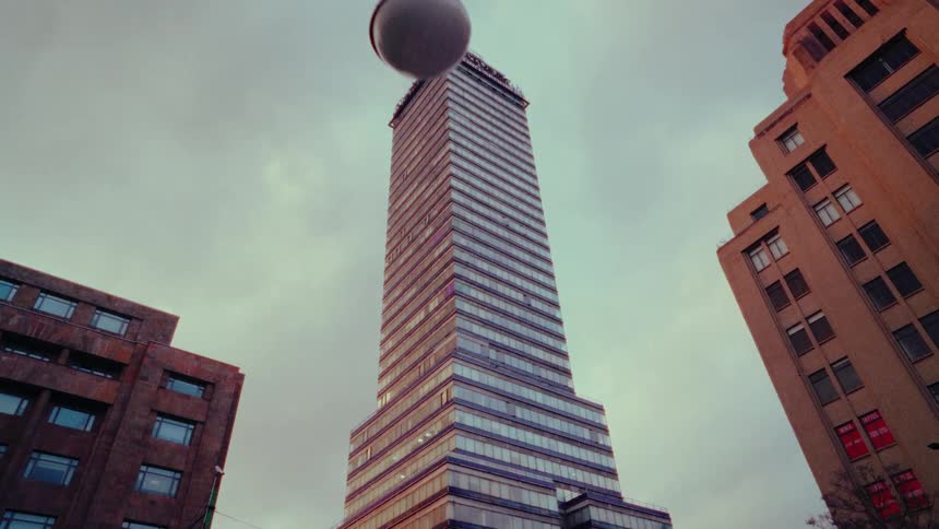A slow dolly shot looking up at the iconic Torre Latinoamericana skyscraper in Mexico City on an overcast day