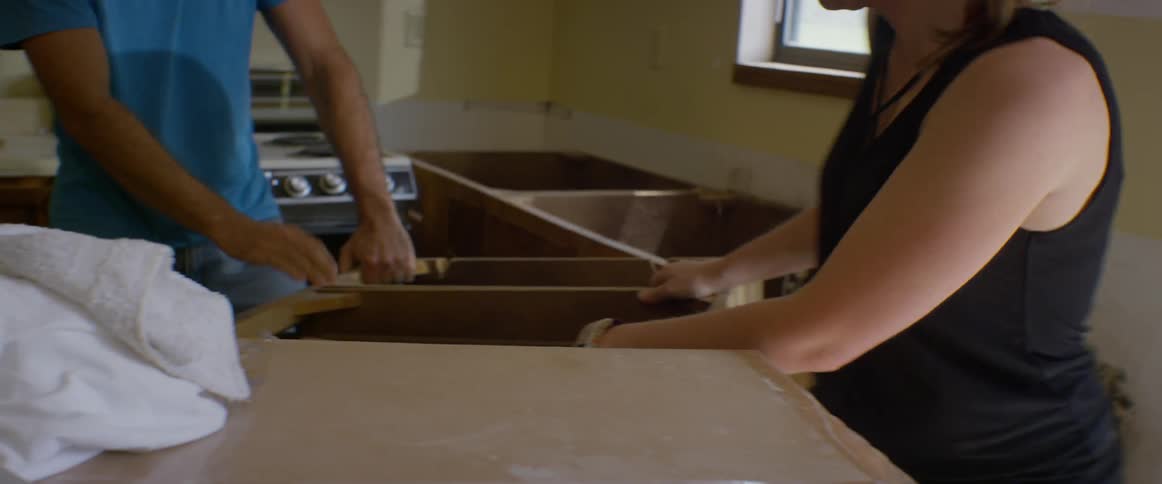 Man and woman move a large counter out of kitchen