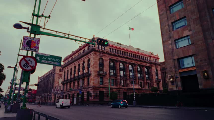 A slow zoom on a historic building in Mexico City with light traffic on an overcast day