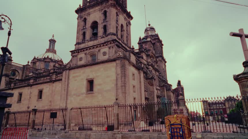 Slow dolly shot towards the historic Mexico City Metropolitan Cathedral under a dramatic, overcast sky