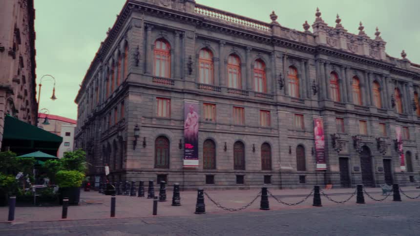 A slow pan across the grand facade of the Museo Nacional de Arte (MUNAL) on a quiet, overcast day in Mexico City's historic center