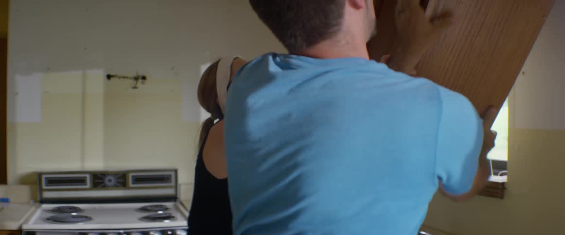 Man and woman pull kitchen cabinet off wall