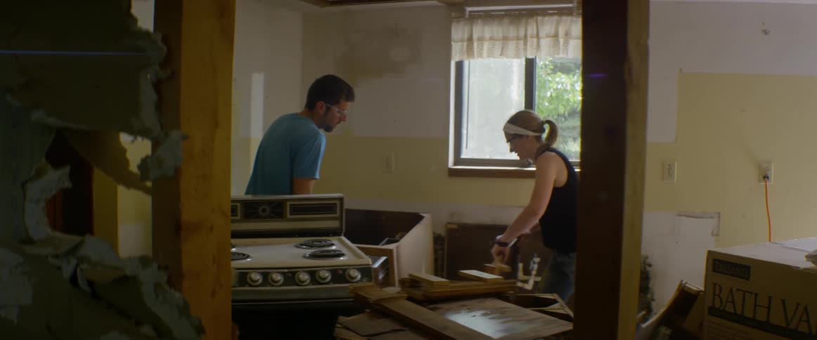 A man and woman demolish a kitchen